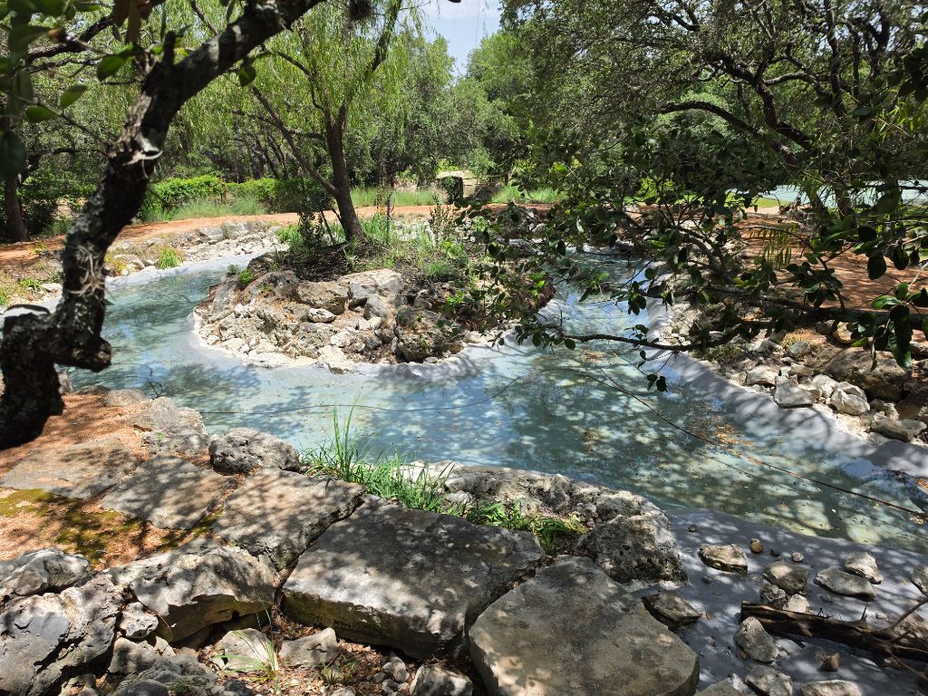 Pond Renovation Before – Shallow water with rock banks and overgrown trees