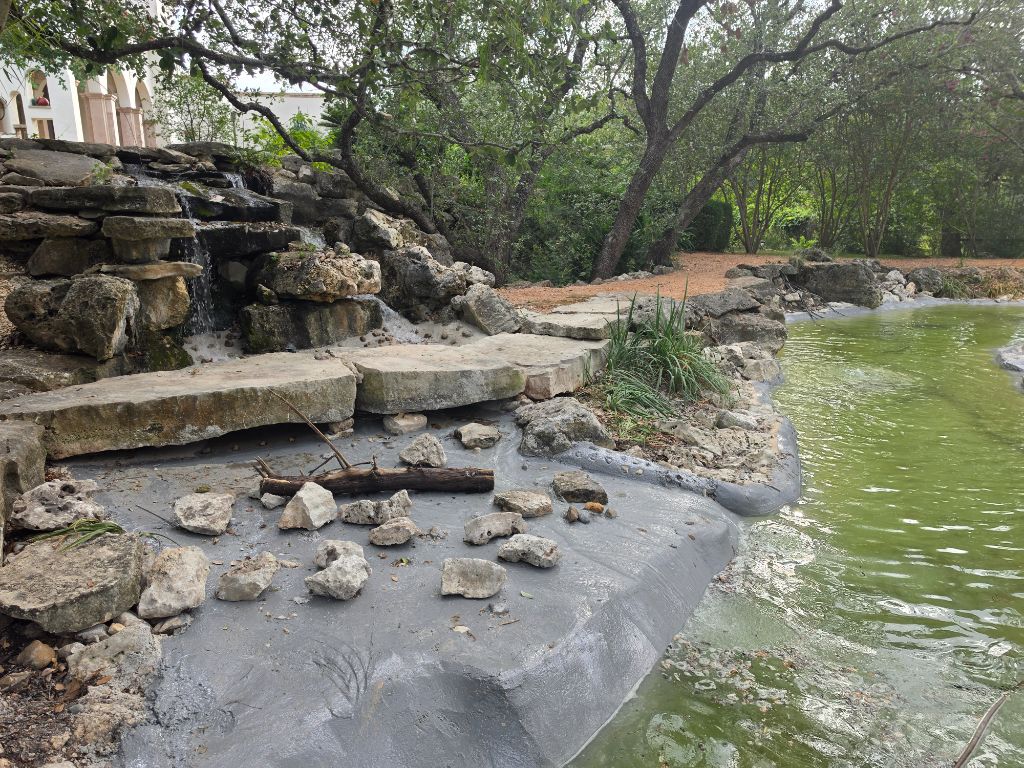 Pond Renovation After – Waterfall and renovated rock bank with cleared pond